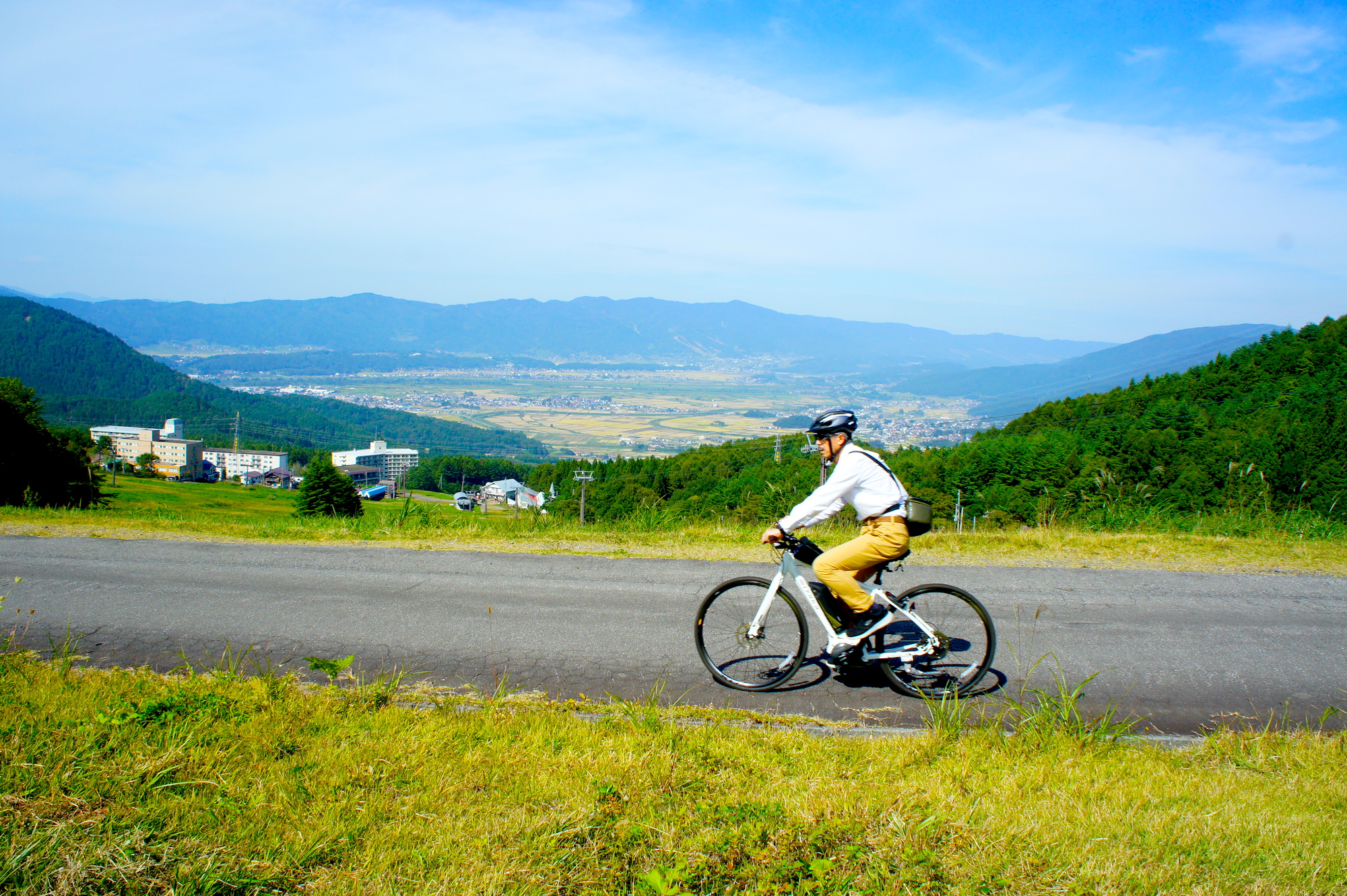 E-bikeサイクリングで眺めの良い木島平スキー場を横切る道を走る。